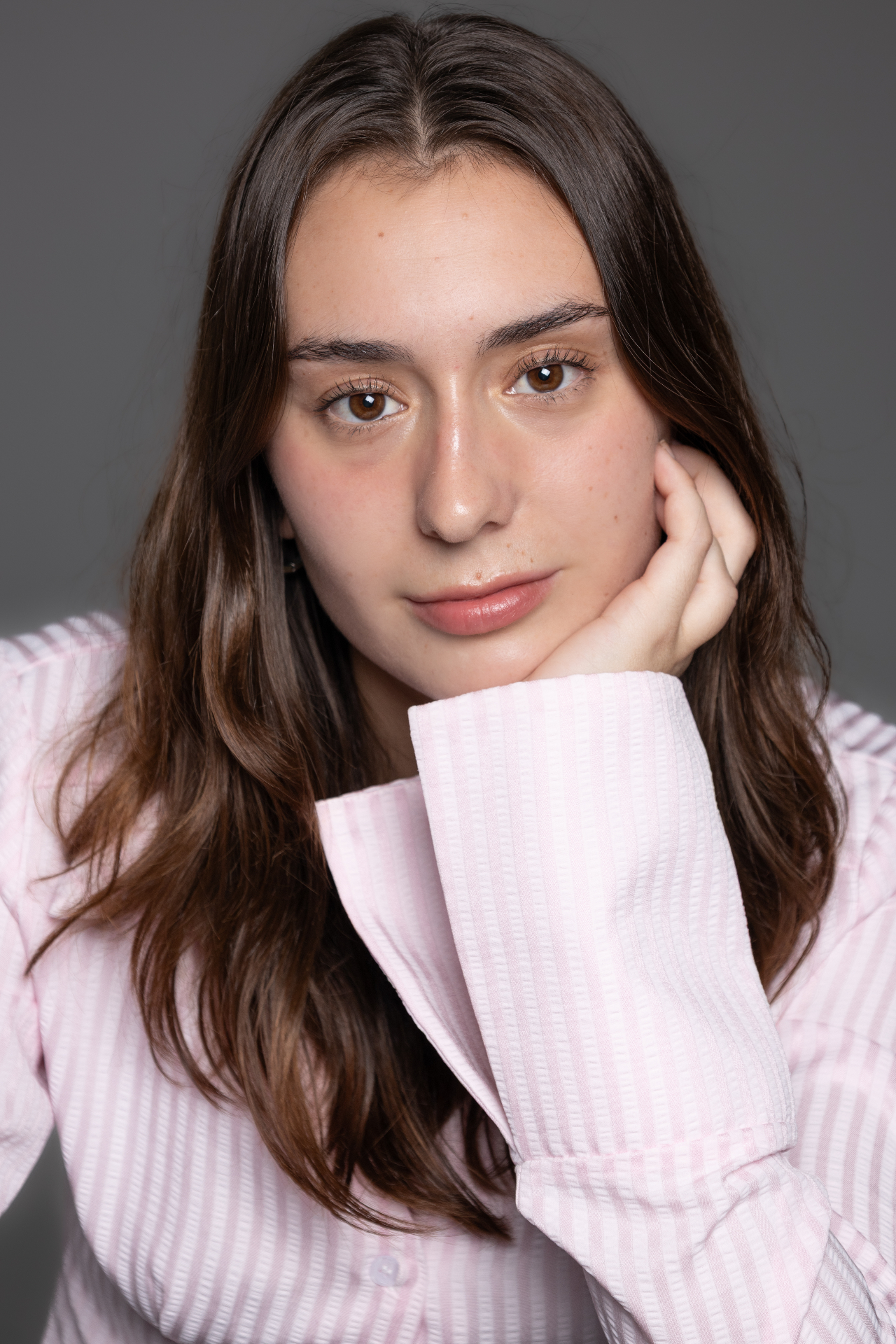 Ada Montserrat con camisa rosa apoyando el rostro en la mano